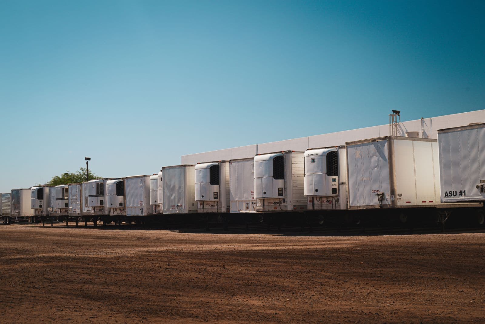 Row of semi trailers lined up in a wide open parking yard
